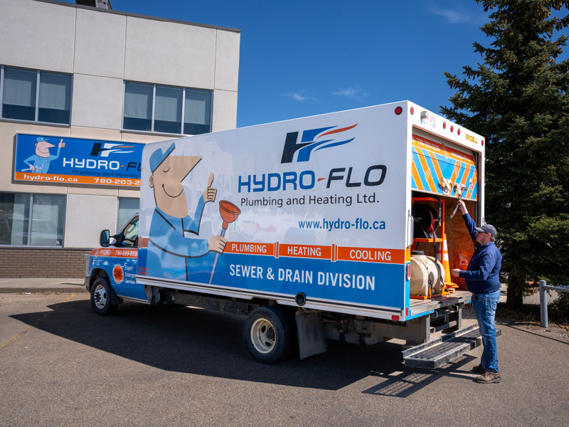 Man lifting back door of Hydro-Flo truck in Edmonton, AB 