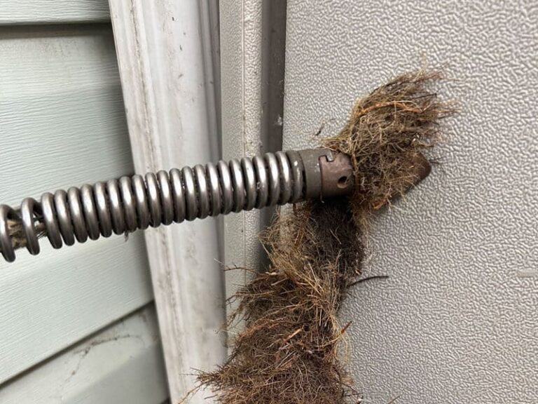 A close-up of a metal covered with roots, showing the need for Root Removal service in Edmonton, AB